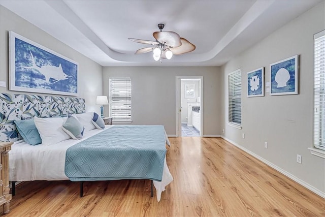123 Sea Mist Dr, Aransas Pass, TX 78336 - bedroom featuring a raised ceiling, light wood-type flooring, baseboards, and a ceiling fan