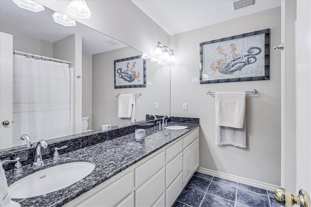 bathroom featuring tile patterned floors, vanity, and toilet