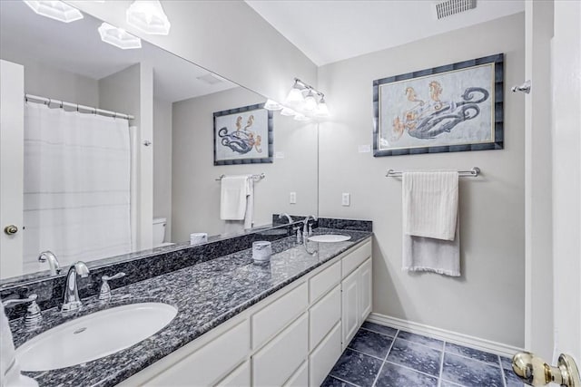 123 Sea Mist Dr, Aransas Pass, TX 78336 - bathroom featuring baseboards, double vanity, and toilet