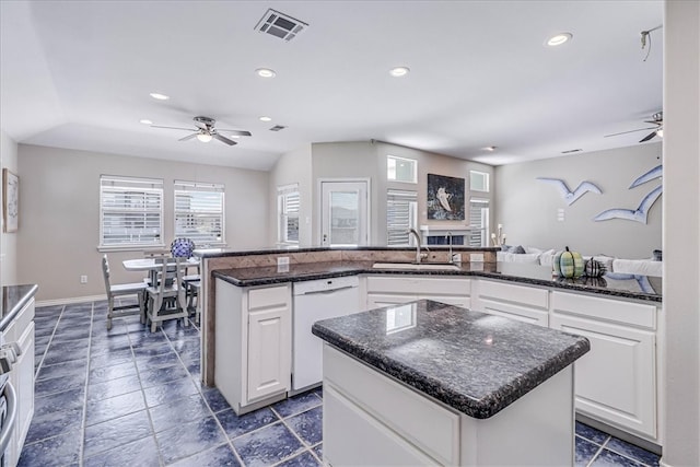 kitchen with dishwasher, a center island, and white cabinets