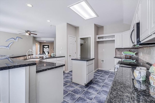 123 Sea Mist Dr, Aransas Pass, TX 78336 - kitchen with stainless steel appliances, a ceiling fan, a center island, a sink, and white cabinets