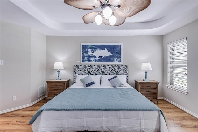 123 Sea Mist Dr, Aransas Pass, TX 78336 - bedroom with wood finished floors, a raised ceiling, and baseboards