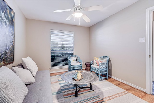 living area with hardwood / wood-style floors and ceiling fan