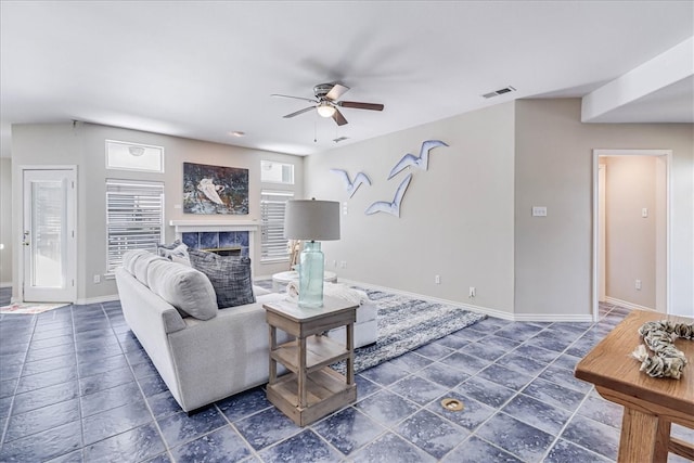 living room featuring ceiling fan and a fireplace