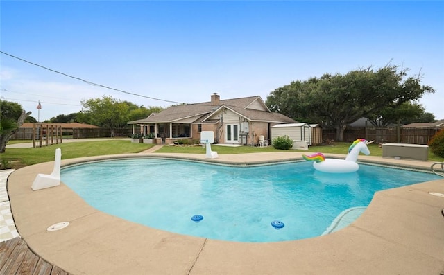 view of pool featuring a storage unit and a yard