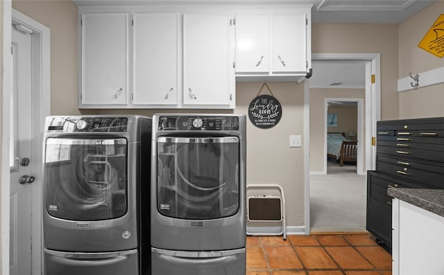 laundry area featuring cabinets, washer and dryer, and light tile patterned floors