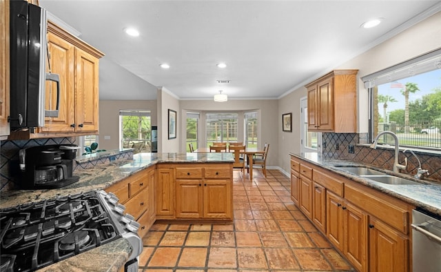 kitchen featuring stainless steel appliances, sink, kitchen peninsula, light stone counters, and decorative backsplash