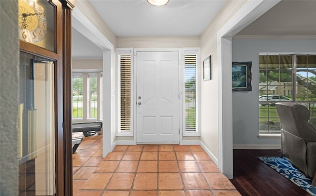 entrance foyer featuring ornamental molding, light wood-type flooring, and a wealth of natural light