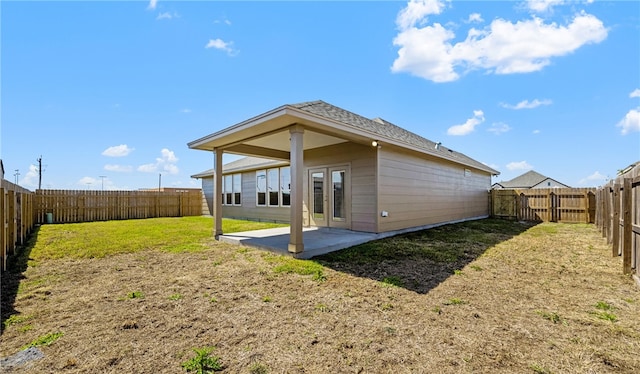 rear view of property with french doors, a patio area, a lawn, and a fenced backyard