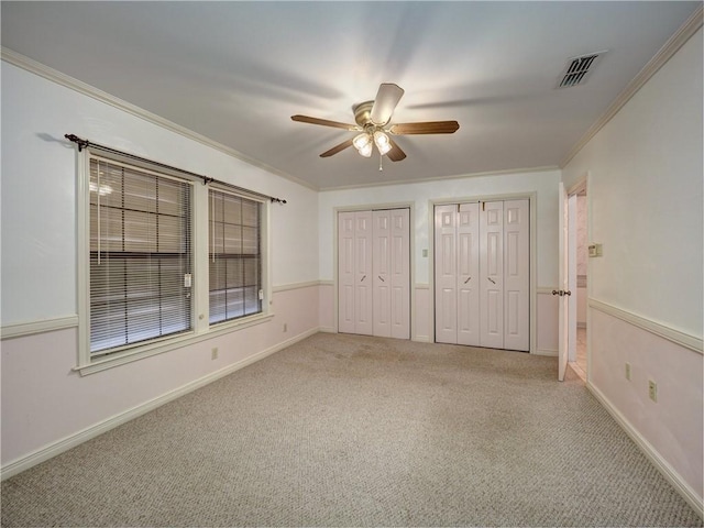 4821 Kosarek Dr, Corpus Christi, TX 78415 - unfurnished bedroom featuring two closets, ornamental molding, light carpet, and ceiling fan