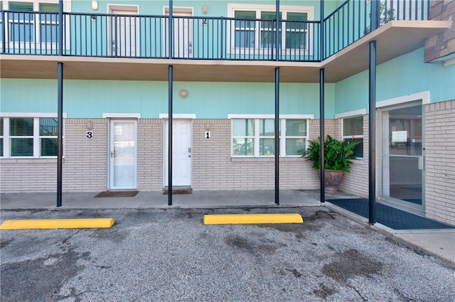 view of exterior entry featuring a balcony