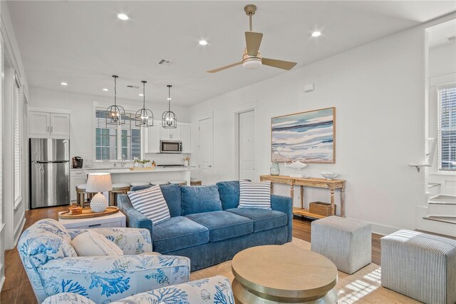 living room with light hardwood / wood-style floors and ceiling fan