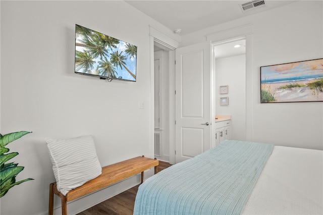 bedroom with dark hardwood / wood-style flooring and ensuite bathroom