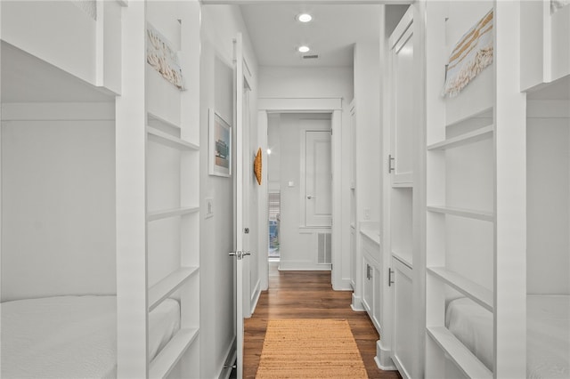 corridor with dark hardwood / wood-style floors and built in features