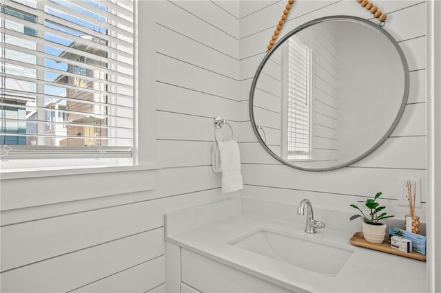 bathroom featuring wood walls and vanity