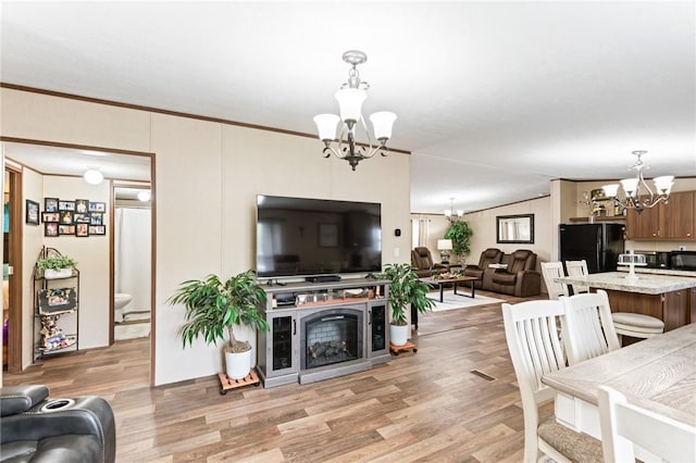 living room featuring ornamental molding, light hardwood / wood-style floors, and a notable chandelier