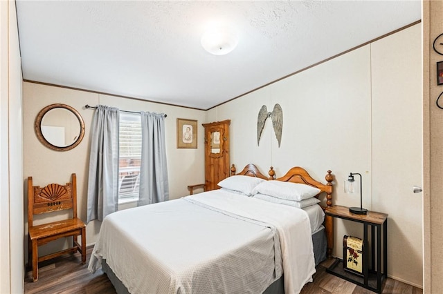 bedroom with a textured ceiling, dark hardwood / wood-style flooring, and crown molding