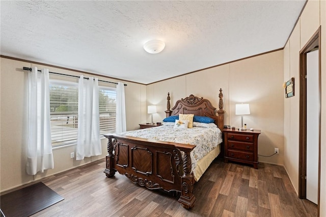 bedroom with crown molding, dark hardwood / wood-style flooring, and a textured ceiling