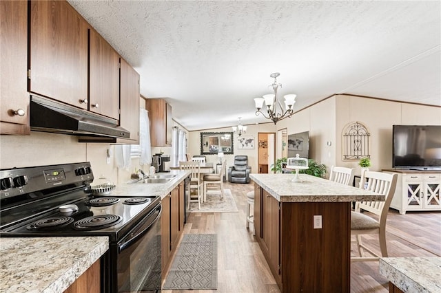 kitchen with black range with electric stovetop, vaulted ceiling, a textured ceiling, decorative light fixtures, and light hardwood / wood-style floors