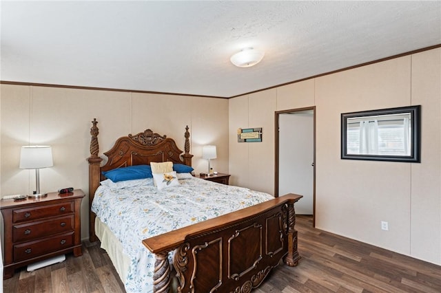 bedroom with dark hardwood / wood-style flooring, ornamental molding, and a textured ceiling