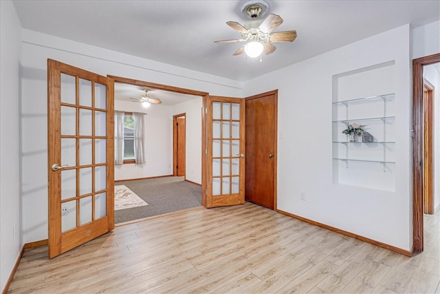 empty room featuring french doors, ceiling fan, and light hardwood / wood-style flooring