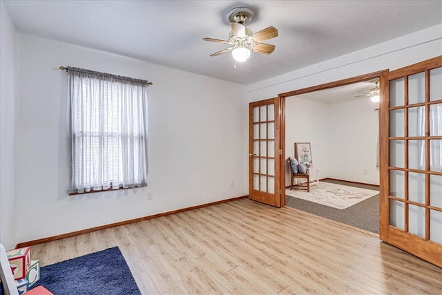 spare room with light hardwood / wood-style floors, ceiling fan, and french doors