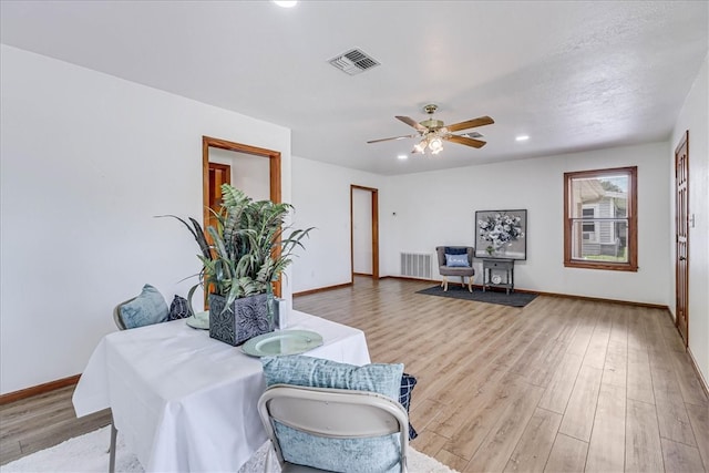 living area featuring ceiling fan and light hardwood / wood-style floors