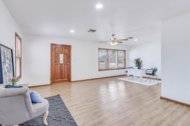 sitting room with light wood-type flooring and ceiling fan