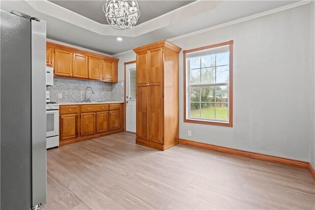 4446 Naples St, Corpus Christi, TX 78415 - kitchen with light countertops, white appliances, a chandelier, backsplash, and light wood-style flooring