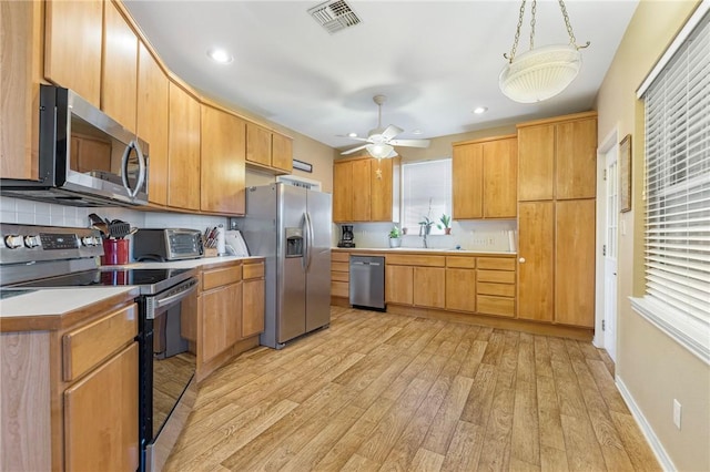 kitchen with ceiling fan, stainless steel appliances, tasteful backsplash, light hardwood / wood-style floors, and decorative light fixtures