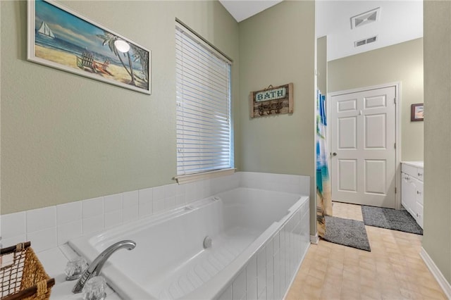 bathroom featuring vanity and a relaxing tiled tub