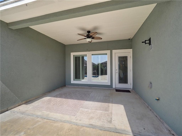 property entrance featuring a patio, stucco siding, and ceiling fan