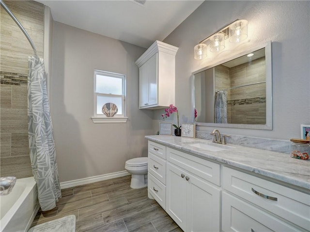 bathroom featuring wood finish floors, toilet, shower / bath combo, baseboards, and vanity