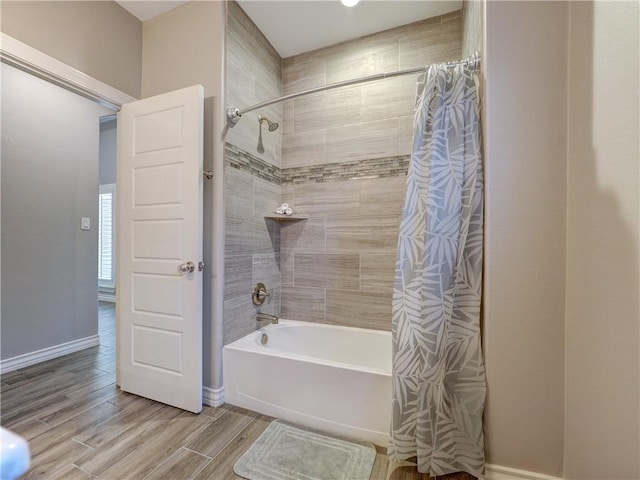 full bath with baseboards, shower / bath combo, and wood finish floors