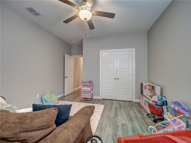 interior space featuring visible vents, baseboards, wood finished floors, and a ceiling fan