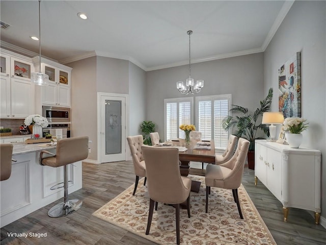 dining space featuring crown molding, a notable chandelier, and dark wood-style floors