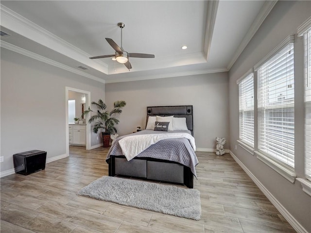 bedroom with light wood-style flooring, baseboards, and a tray ceiling