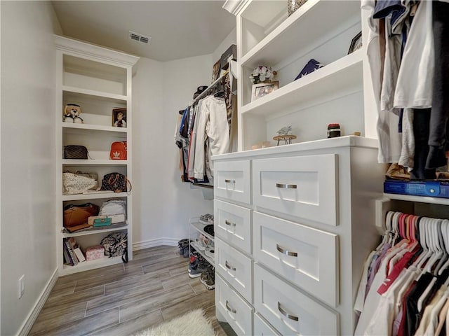 walk in closet featuring visible vents and wood finish floors