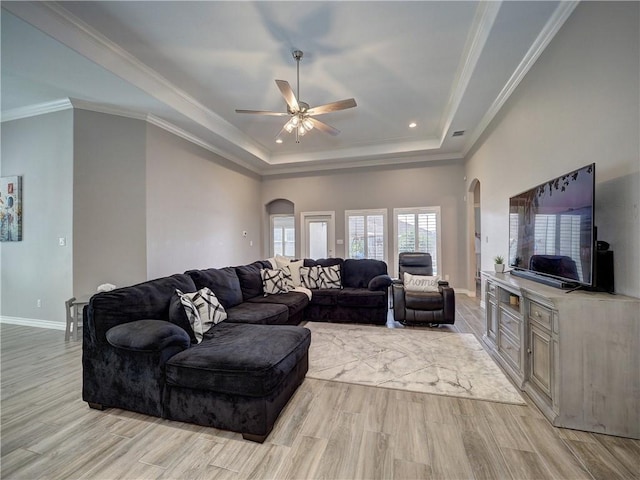 living area featuring arched walkways, light wood-style flooring, and a ceiling fan