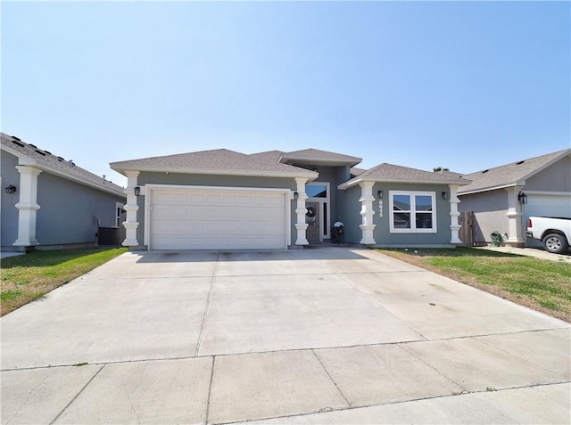 view of front facade with central AC unit, stucco siding, driveway, and a garage