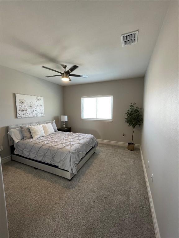 bedroom with visible vents, carpet flooring, a ceiling fan, and baseboards