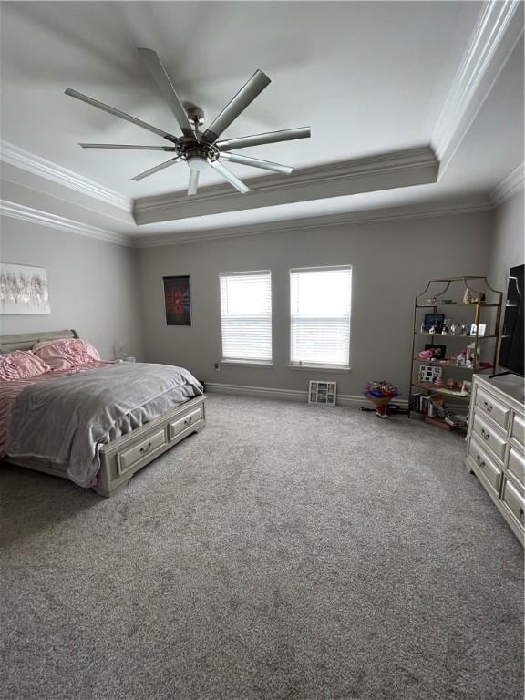 bedroom featuring a ceiling fan, baseboards, a tray ceiling, crown molding, and carpet flooring