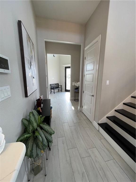 hallway with stairs, baseboards, and wood tiled floor