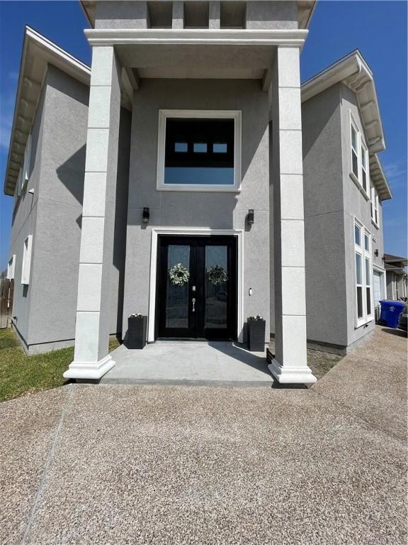 entrance to property with french doors and stucco siding