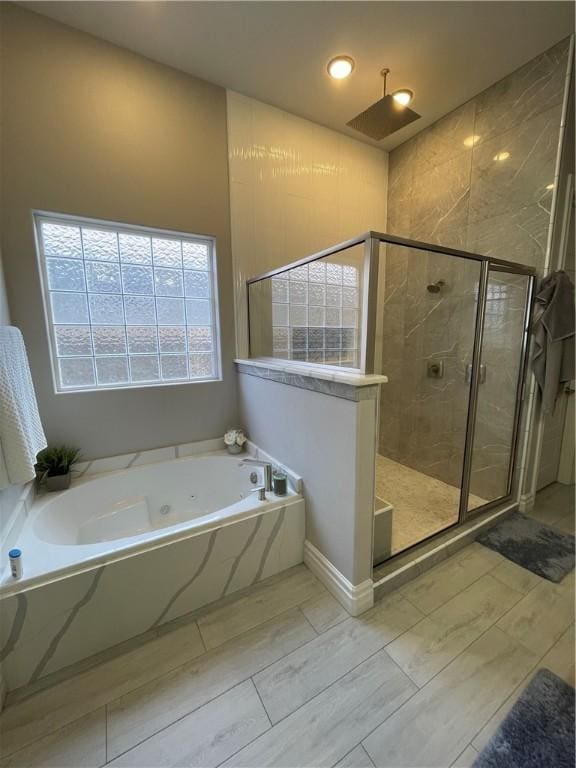 full bathroom with a shower stall and a bath