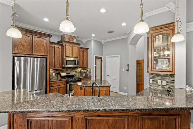 8245 Rock Crest Dr, Corpus Christi, TX 78414 - kitchen featuring appliances with stainless steel finishes, tasteful backsplash, arched walkways, a kitchen island, and recessed lighting