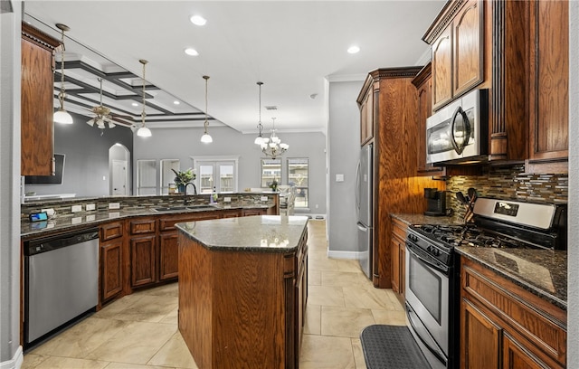 8245 Rock Crest Dr, Corpus Christi, TX 78414 - kitchen featuring stainless steel appliances, tasteful backsplash, ceiling fan, arched walkways, and a kitchen island