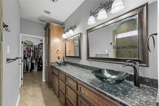 8245 Rock Crest Dr, Corpus Christi, TX 78414 - full bathroom with double vanity, marble look tiles, and a walk in closet