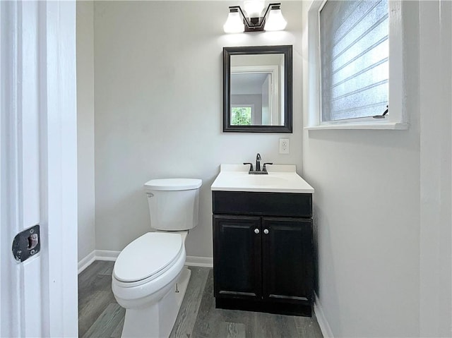 6042 Hugo Dr, Corpus Christi, TX 78412 - half bath featuring vanity, toilet, wood finished floors, and baseboards