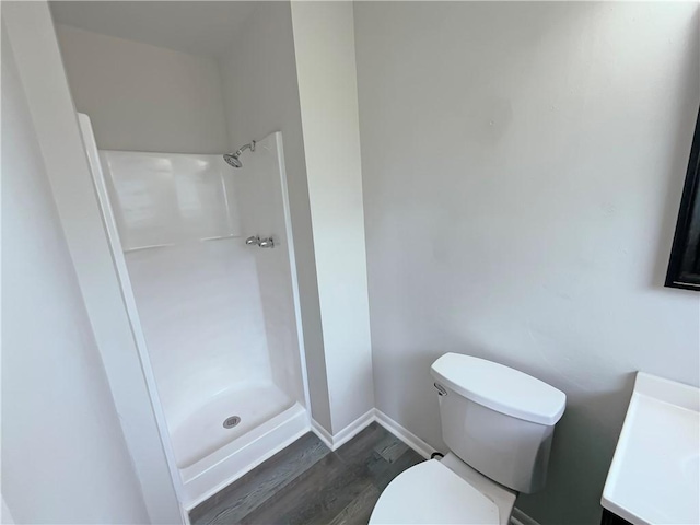 6042 Hugo Dr, Corpus Christi, TX 78412 - full bathroom featuring toilet, wood finished floors, a walk in shower, vanity, and baseboards